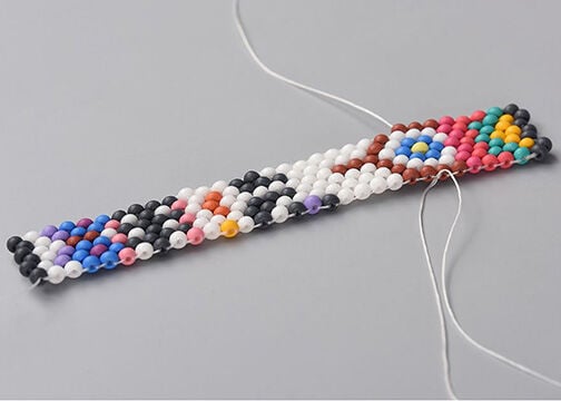 Side view of Step 6a, showing the two threads meeting on the right column. Threads are being tied together.